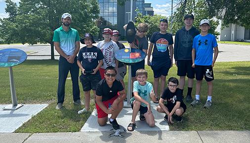 Campers and Jonathan Ashdown pose next to Voyage display station